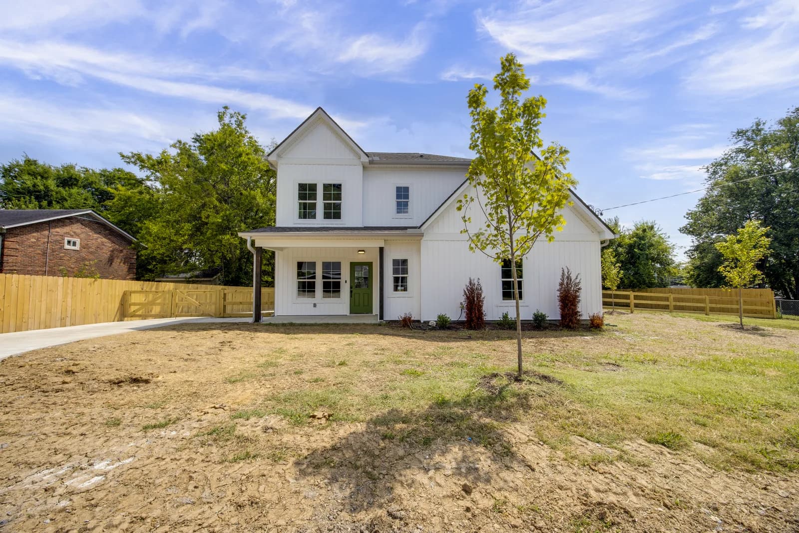 Rear of 3304 Leondale Ter — white siding, covered porch, and a newly fenced yard