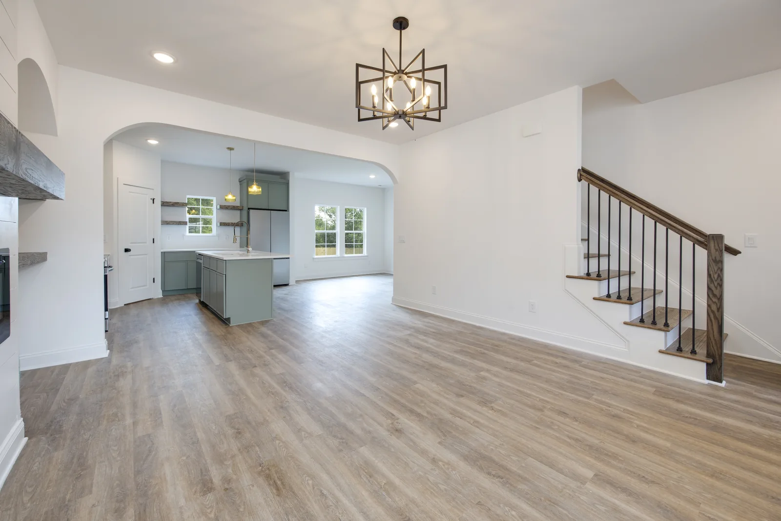 Living room and the oak-railed staircase at the front entry