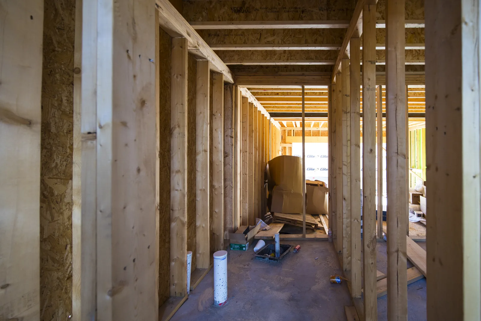 Framed corridor inside one unit, mechanical rough-in underway
