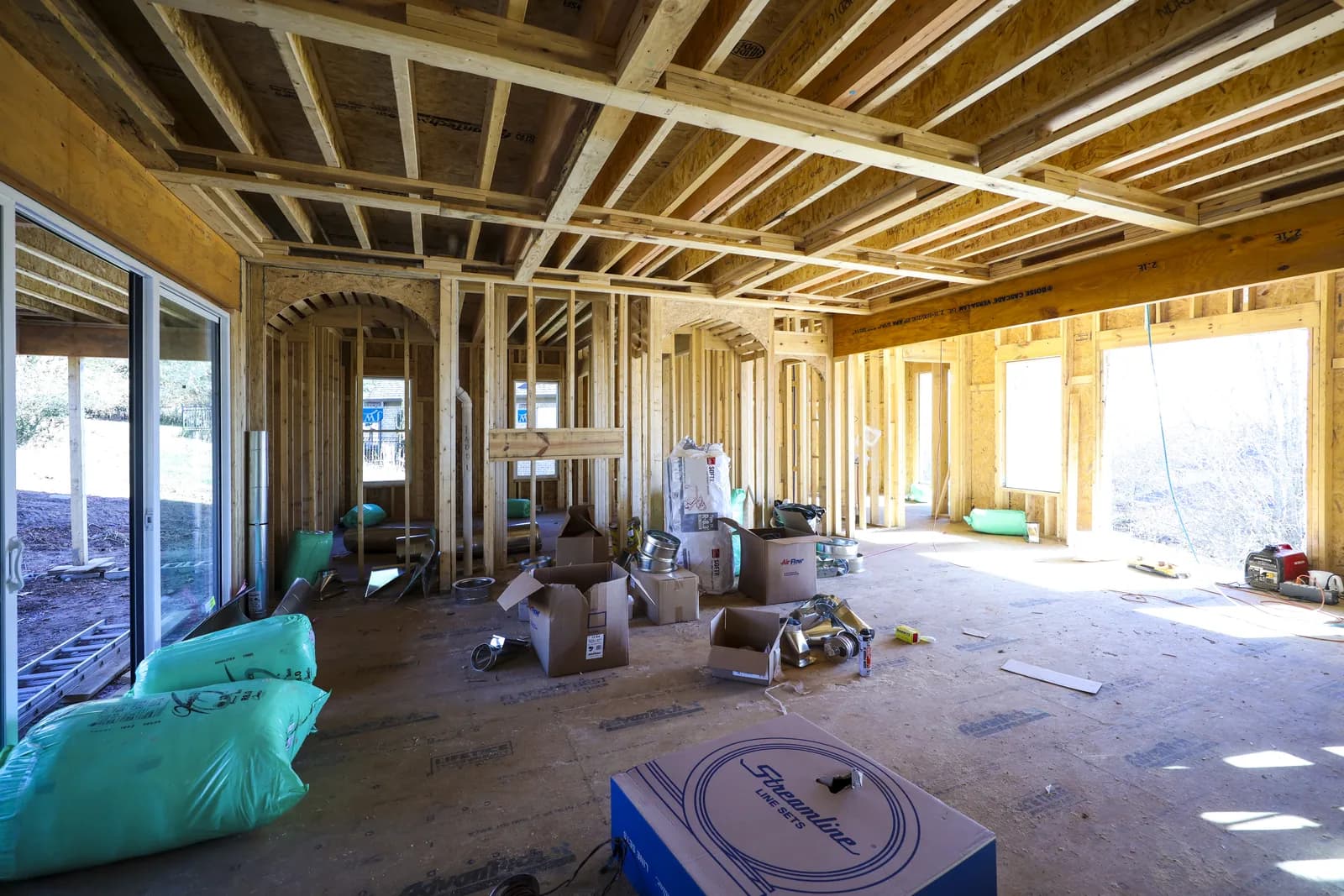 Framed great room with a full wall of window openings onto the back