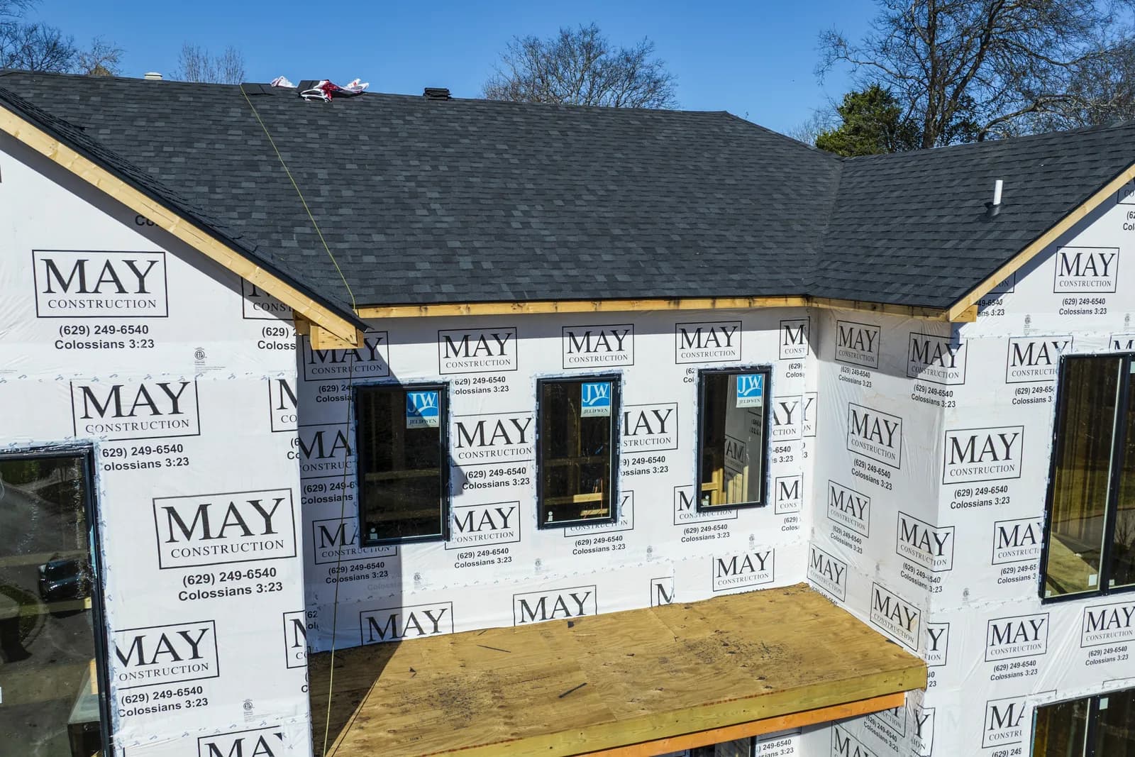 Shingled rear roofline over MAY-branded housewrap