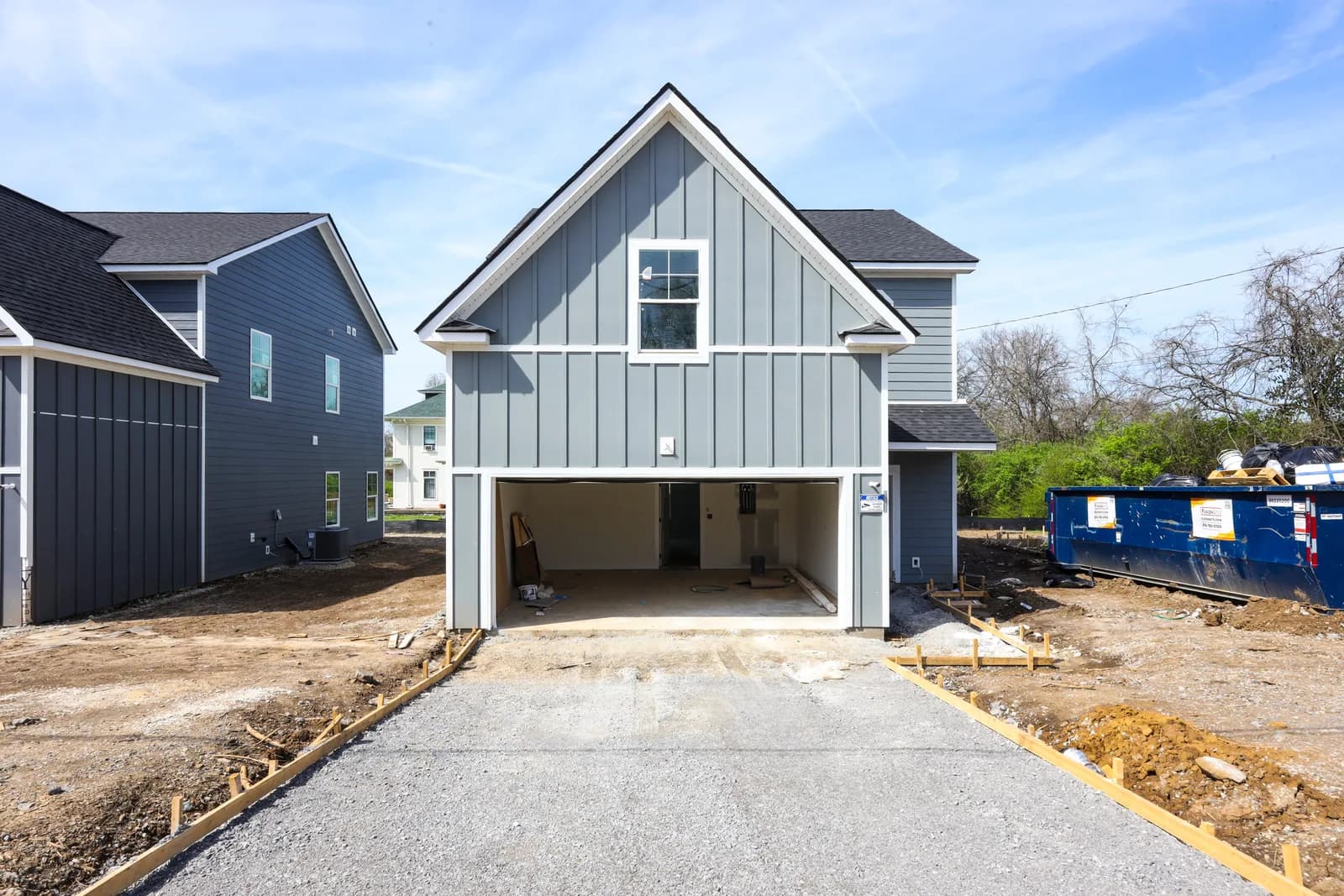 Front elevation of one Forest Park home — board-and-batten gable over the framed garage bay