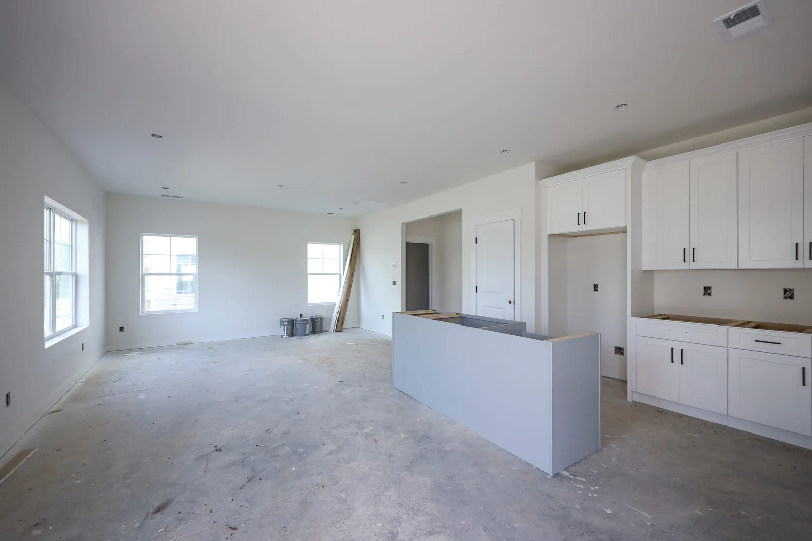 Main living area at drywall stage, kitchen island framed in