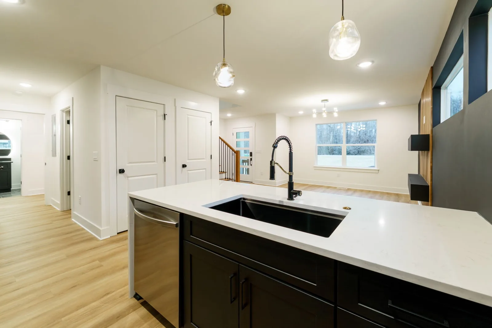 Kitchen island with black cabinetry, white quartz counters, and stainless appliances